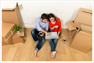 Couple sitting on floor in their new house purchased recently on mortgage