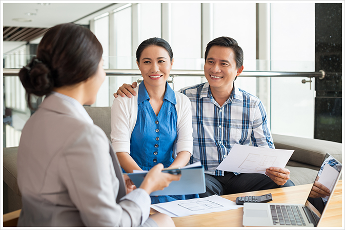 A happy couple meeting a mortgage broker