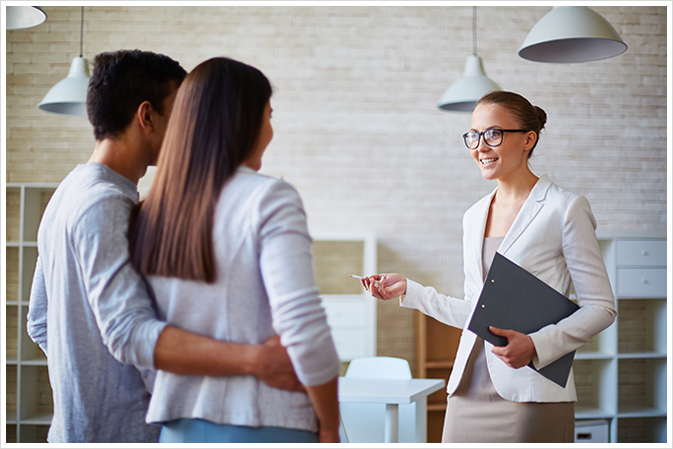 female realtor giving mortgage tips to first time home buyer couple