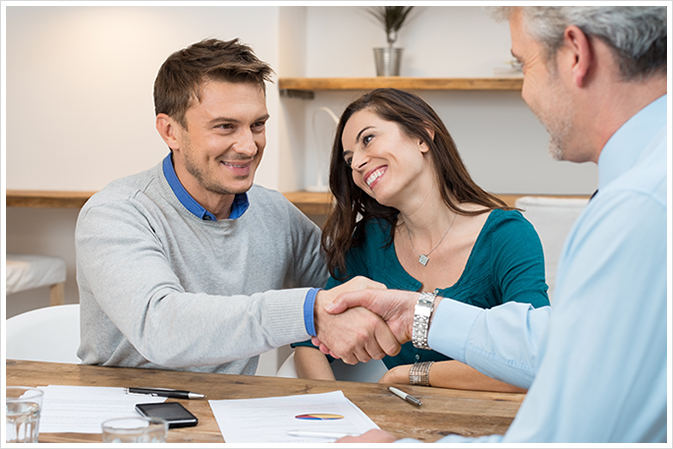 A happy couple completing their mortgage refinancing with a broker