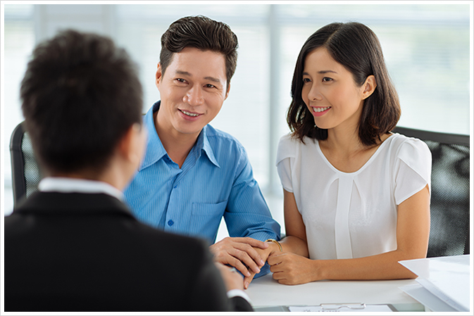 First Time Home Buyer Couple Sitting With Mortgage Agent